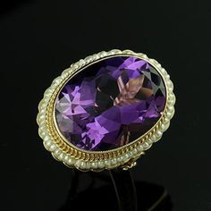 Amethyst Ring Victorian Style Cocktail Large Oval Seed Pearls Yellow Gold Bezel Set Gemstone There is nothing subtle and delicate about this ring. Flashy, expensive looking ring made of 14K yellow gold with a luxurious looking, large, oval amethyst (approximately 12ct) set in bezel and surrounded by a halo of gold twisted wire and oriental seed pearls. Sizes: 4-8 (smaller and larger sizes are available as custom orders.) PROUDLY MADE FROM SCRATCH IN NEW YORK CITY. Please allow 2-3 weeks to compl Oval Amethyst Ring With Gemstone Accents For Formal Occasions, Heirloom Oval Amethyst Jewelry, Exquisite Oval Amethyst Ring For Wedding, Exquisite Oval Amethyst Ring For Anniversary, Exquisite Oval Amethyst Wedding Ring, Oval Purple Amethyst Ring With 17 Jewels, Heirloom Oval Amethyst Ring With Accent Stones, Oval Multi-stone Amethyst Gemstones, Oval Amethyst Ring With Gemstone Accents