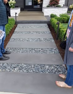 two people standing on the side of a walkway