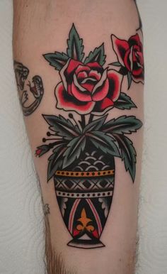 a flower pot with red roses on the side of his leg is shown in this tattoo design