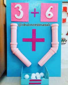 a blue box filled with balls next to a pink and white sign that says 3 +