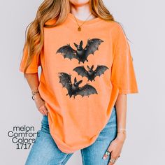 Flying Bats Shirt, Comfort Colors T-shirt, Flying Bat Graphic Tee, Gift for Halloween Season, Trick-or-Treat Shirt, Urban Life T-shirt, Printed front and back. Back has only one bat, front view has 3 bats. About Comfort Colors 1717 ------------------------------------- Comfort Colors 1717 adult unisex short sleeve heavyweight t-shirt is garment-dyed and soft-washed for a comfortable vintage look and feel. The soft-washed, garment-dyed fabric brings extra coziness to your wardrobe while the relaxed fit makes it an excellent daily choice. The double-needle stitching throughout the tee makes it highly durable while the lack of side-seams helps the shirt retain its tubular shape. ✨ 100% ring-spun cotton ✨ Preshrunk, Soft-washed, Garment-dyed fabric ✨ Without side seams, Double needle stitching Casual Orange Tops For Halloween, Funny Orange Tops For Fall, Funny Orange Top For Fall, Grunge Tops With Funny Print For Halloween, Orange Cotton Tops For Halloween, Orange Crew Neck Top For Halloween, Halloween Novelty Tops With Screen Print, Novelty Halloween Tops With Screen Print, Novelty Halloween Screen Print Tops