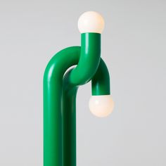 a green lamp with two white balls on it's end and one light that is attached to the pole