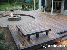 a wooden deck with benches and fire pit