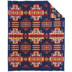 an orange and blue blanket on top of a white surface with a black pattern in the middle