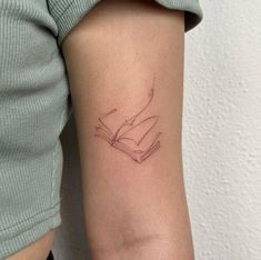 a woman's arm with a tattoo on it that has a book in it