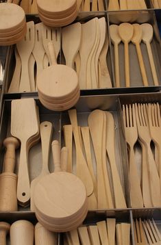 wooden utensils and spoons are arranged neatly in a drawer with dividers