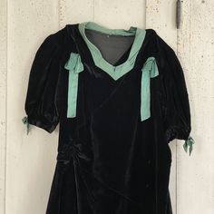 Hello and Welcome to the Textile Trunk! Please follow us on Instagram we are @textiletrunk I date it to around the 1920-1940? or perhaps a bit earlier. I love the cheeky look of only one long sleeve! Made of black velvet with green satin collar and bows ~ I LOVE the ruched waist!! ~ ( Dress E 8R) MEASUREMENTS : This gorgeous Vintage French dress measures : 57 inches long 15 inches across the shoulders 33 inch waist 38 inches around the chest CONDITION : This lovely dress is in as found, not fres Fitted Vintage Victorian Dress For Theater, Black Vintage Victorian Dress, Long Sleeve Victorian Dress For Vintage Events, Black Vintage Dress For Costume, Vintage Long Sleeve Victorian Dress For Vintage Fashion, Vintage Long Sleeve Theater Dress, Long Sleeve Victorian Dress For Vintage Fashion, Retro Long Sleeve Vintage Dress For Costume, Retro Long Sleeve Vintage Costume Dress