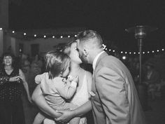 a man and woman kissing while standing next to each other on a dancefloor