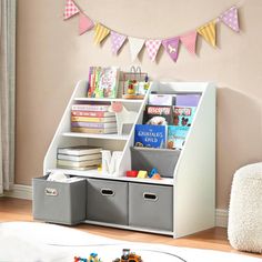 a child's book shelf with two bins and some books on it in a room