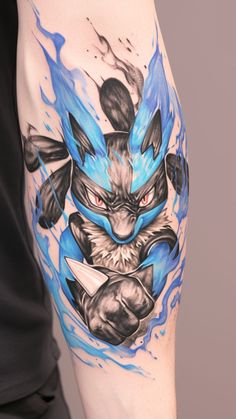 a man with a tattoo on his arm that has an image of a blue and black pokemon