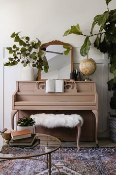 a living room with a piano, mirror and plants