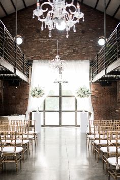 an indoor wedding venue with chandelier and chairs