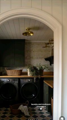 a washer and dryer are in the middle of a kitchen with black cabinets