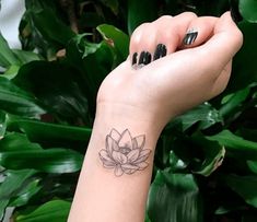 a woman's wrist tattoo with a lotus flower on the left side of her arm