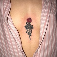 a woman's chest with a rose and snake tattoo on her left side ribcage