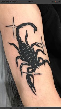 a black scorpion tattoo on the arm