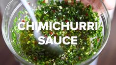 a person holding a spoon in a bowl filled with green stuff and the words chimichurri sauce above it