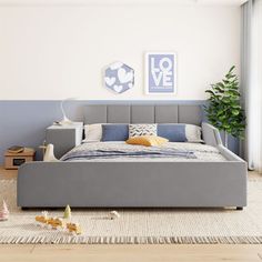 a bed room with a neatly made bed next to a window and a potted plant