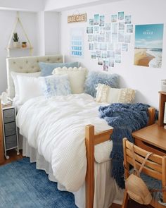 a bedroom with a bed, desk and pictures on the wall above it in blue tones