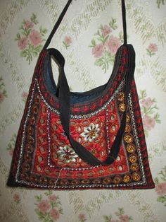 "Pretty shoulder\\handbag made of soft velour. The back is plain black, the front is embroidered and beaded in reds and golds. There are no pockets inside, it has a zip top. A perfect evening bag. Width;  10\" Height;  11\" Strap;  20\" Made in France cotton mix" Red Shoulder Bag With Handwork For Festivals, Red Handwork Shoulder Bag For Festivals, Festival Red Shoulder Bag With Handwork, Black Shoulder Bag For Everyday Use And Festivals, Black Shoulder Bag For Everyday And Festivals, Beaded Bags For Everyday Use And Festivals, Red Shoulder Bag For Daily Use And Festivals, Everyday Beaded Bags For Festivals, Traditional Red Bags For Festival