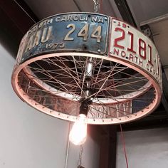 a light hanging from the ceiling in a building with an old sign on it's side