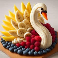 a cake made to look like a bird with bananas, raspberries and banana slices