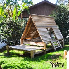 a wooden structure sitting in the grass next to trees