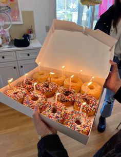 a box filled with lots of donuts covered in sprinkles