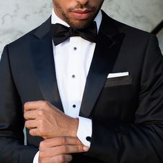 a man wearing a black tuxedo and bow tie