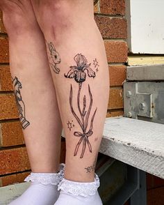 the legs of a woman with tattoos on them and white socks in front of a brick wall