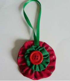 a red and green flower ornament with a button on it