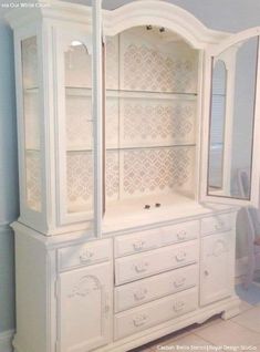 a white china cabinet with glass doors and drawers