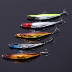 five different types of fishing lures on a black surface