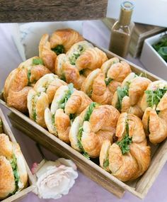 two wooden boxes filled with pastries on top of a purple table covered in flowers