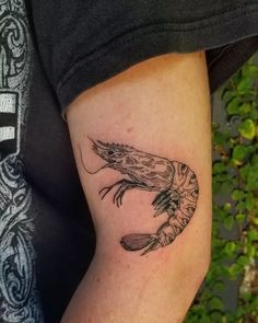 a person with a tattoo on their arm that has a shrimp in it's claws