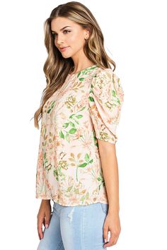 Light, chiffon blouse with a whimsical, floral print. Round neckline with a relax fit and a puff shoulder, short sleeve. Chic and effortless top, looks great paired with denim. CARE | Dry Clean or Hand Wash Cold CONTENTS | 100% Polyester MEASUREMENTS | 25"/63 cm Shoulder to Hem (Size Small) MODEL | 5'8 - wearing a size Small IMPORTED Feminine Floral Print Blouse With Flutter Sleeves, Spring Flutter Sleeve Printed Blouse, Feminine Floral Print Tops With Flutter Sleeves, Spring Floral Print Flutter Sleeve Blouse, Spring Tops With Floral Print And Puff Sleeves, Floral Print Flutter Sleeve Tops For Brunch, Flutter Sleeve Floral Print Top For Brunch, Printed Short Sleeve Tops For Brunch, Flowy Floral Print Top With Puff Sleeves