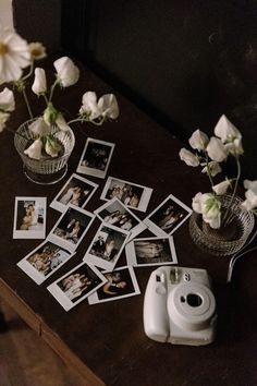 several polaroid pictures are placed on a table next to flowers and an old camera