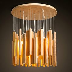 a chandelier made out of wood sticks and glass tubes hanging from the ceiling