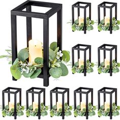 a set of six black candle holders with greenery and candles