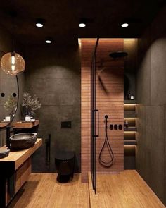 a modern bathroom with wood floors and black fixtures on the walls, along with an open shower