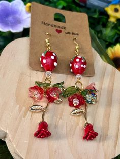 🍓🌹Strawberry, rose and bellflower dangling earrings! Glass strawberry bead, red/green bellflower beads, red rose pendant  ️🍓✨ᠻ𝚊𝚒𝚛𝚢 𝚑𝚊𝚗𝚍𝚖𝚊𝚍𝚎 𝚓𝚎𝚠𝚎𝚕𝚛𝚢🍄🍃 🚚 𝔸𝕝𝕨𝕒𝕪𝕤 𝕗𝕣𝕖𝕖 𝕤𝕙𝕚𝕡𝕡𝕚𝕟𝕘! 🌸 𝐻𝒶𝓃𝒹𝓂𝒶𝒹𝑒 𝓌𝒾𝓉𝒽 𝓁𝑜𝓉𝓈 𝑜𝒻 𝓁𝑜𝓋𝑒 💕 ♡ Free Shipping ♡ Ships within 1-3 days. Tracking info is available on Etsy and I'll update with tracking info 💌 ♡ Packaging ♡ All earrings are set on a display card with cute stickers and free surprise gift 🎁  ♡ Riskfree Guarantee ♡ We know how important it is for your order to be perfect. If you're dissatisfied in any way, please send me a message and I will do my best to make it right for you. Thank you ♡ Whimsical Adjustable Flower Charm Earrings, Whimsical Dangle Flower Earrings, Whimsical Flower-shaped Jewelry, Whimsical Red Flower Jewelry, Whimsical Drop Earrings For Valentine's Day, Earrings Cottagecore, Strawberry Rose, Cottagecore Jewelry, Strawberry Earrings