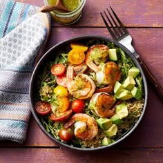 a salad with shrimp, tomatoes, avocado and lettuce in a bowl