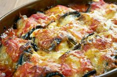 a casserole dish with cheese and spinach in it on a wooden table