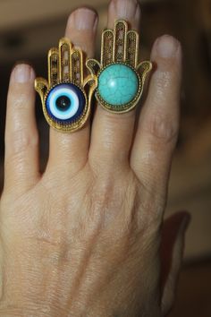 "Gorgeously beautiful, unique and one of a kind large Hamsa evil eye adjustable ring in antique gold or Tibetan silver. Size over 1 1/2\". Since the Hamsa is considered a gift of love it makes it the perfect gift. For those of you who are not familiar with the Hamsa, well, it's a symbol that's been around for thousands of years and is believed to protect and shield against the evil eye, generate positive energy, provide good fortune, health, prosperity and happiness. CUSTOM ORDERS WELCOME DELIVE Spiritual Evil Eye Ring Jewelry, Symbolic Evil Eye Jewelry Ring, Symbolic Evil Eye Ring Jewelry, Adjustable Symbolic Festival Rings, Turquoise Rings Suitable As Gifts, Turquoise Metal Rings As A Gift, Turquoise Metal Rings For Gift, Turquoise Metal Rings For Gifts, Bohemian Evil Eye Metal Jewelry