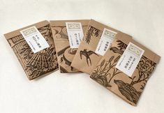 three brown envelopes with birds and plants on them are sitting next to each other