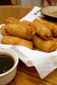 some fried food is on a napkin next to a bowl of dipping sauce