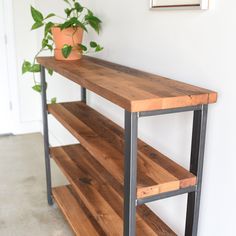 a wooden shelf sitting next to a potted plant