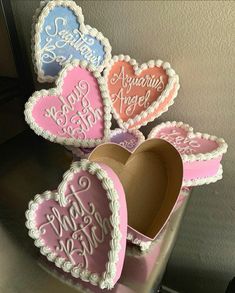 some heart shaped cookies sitting on top of a cake box with the words happy birthday written on them