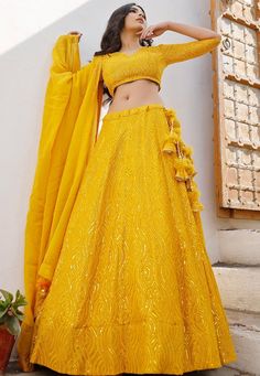 Readymade Faux Georgette Lehenga in Mustard. This attire with Shantoon and Cotton Lining is Enhanced with Fancy Tassels, Resham and Sequins Work. Available with a Faux Georgette Mustard Choli Crafted in V Neck and Elbow Sleeves and a Faux Georgette Dupatta in MustardThe Choli and Lehenga Lengths are 14 and 42 inches respectively. This is perfect for Haldi function also .Do Note: Accessories shown in the image are for presentation purposes only. (Slight variation in actual color vs. image is poss Yellow Georgette Lehenga, Brocade Sets With Gota Work For Reception, Reception Brocade Sets With Gota Work, Brocade Gota Work Sets For Navratri, Navratri Brocade Sets With Gota Work, Festive Gold Gown With Dori Work, Anarkali Brocade Choli With Gota Work, Anarkali Style Brocade Choli With Gota Work, Brocade Lehenga With Gota Work For Festivals