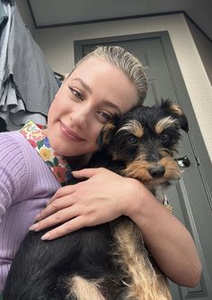 a woman holding a small dog in her arms